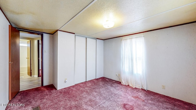 unfurnished room featuring carpet floors and a textured ceiling