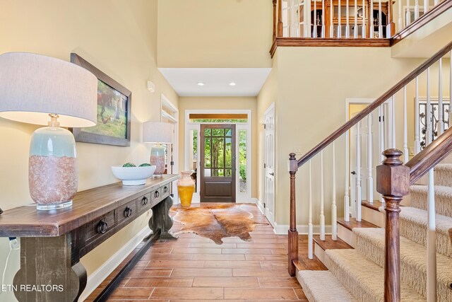 foyer entrance featuring wood-type flooring and a high ceiling