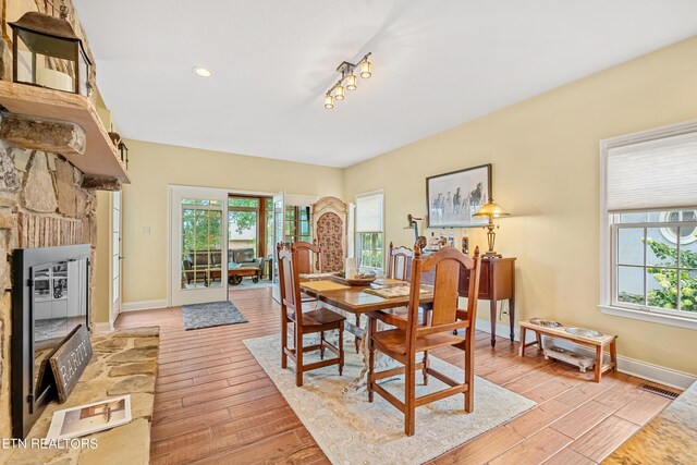 dining space with light hardwood / wood-style flooring and a fireplace