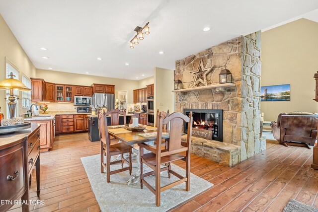 dining space with light hardwood / wood-style floors, a fireplace, and sink