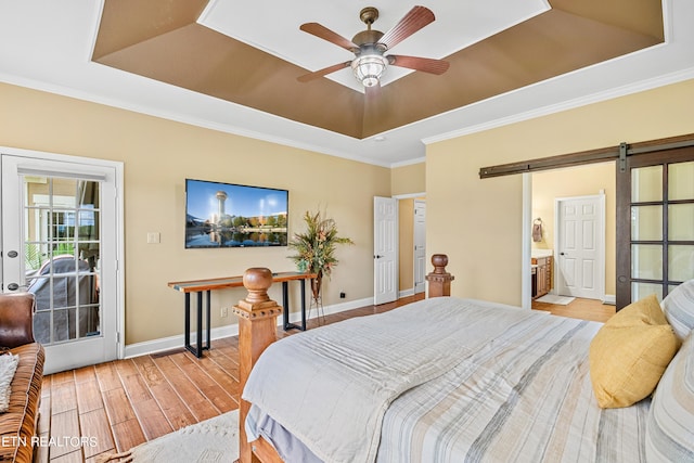 223 Osprey Cir, Vonore, TN 37885 - bedroom featuring a tray ceiling, light wood-type flooring, access to outside, baseboards, and a barn door
