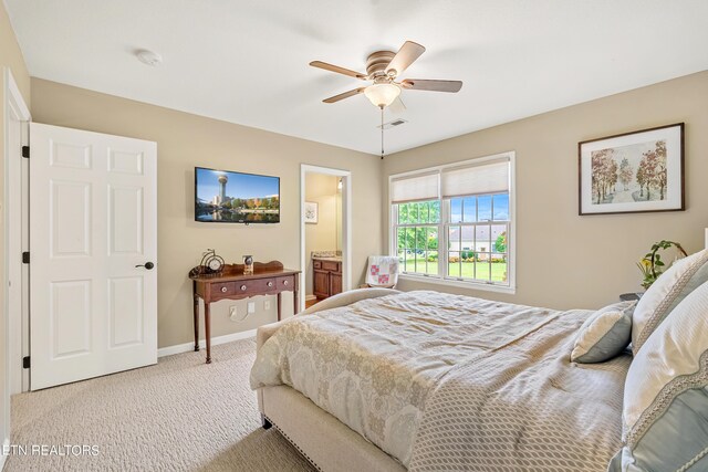 bedroom with carpet floors, connected bathroom, and ceiling fan