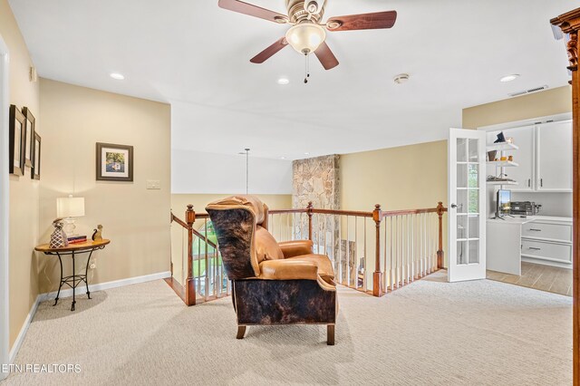 sitting room with ceiling fan and light hardwood / wood-style floors