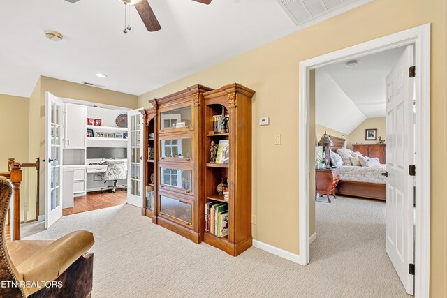 hallway with lofted ceiling and light carpet