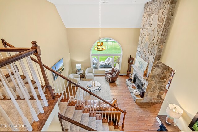 interior space featuring hardwood / wood-style flooring, a fireplace, a chandelier, and high vaulted ceiling