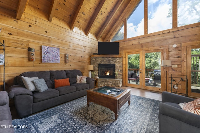 living room with beamed ceiling, wood walls, wooden ceiling, and high vaulted ceiling