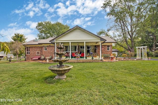 rear view of property featuring a yard and a patio