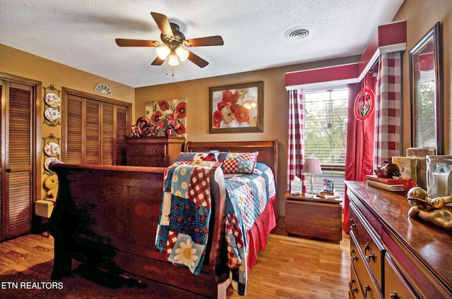 bedroom featuring light wood-type flooring, ceiling fan, and a textured ceiling