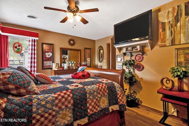 bedroom featuring a textured ceiling, ceiling fan, and hardwood / wood-style flooring