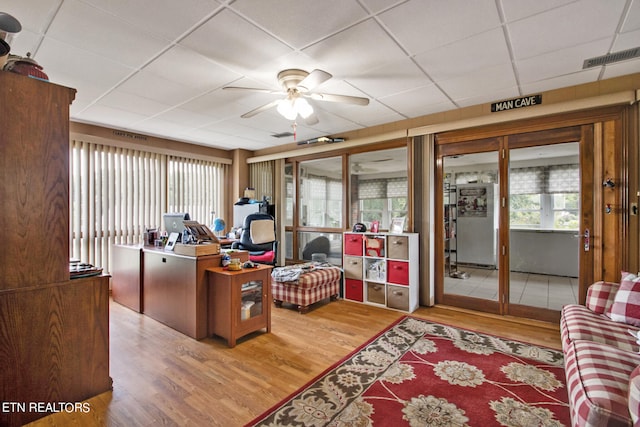 office featuring ceiling fan, a drop ceiling, and hardwood / wood-style floors