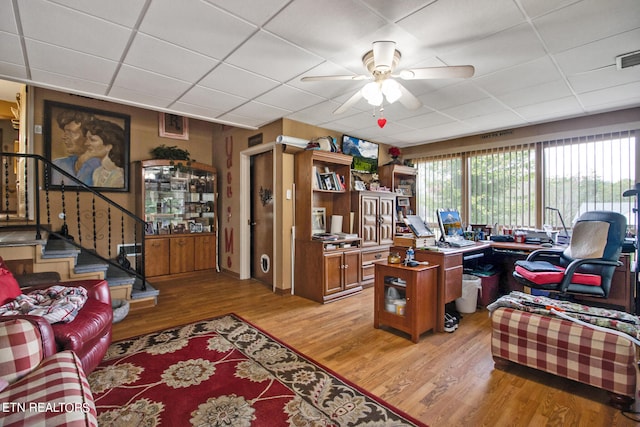 office area with ceiling fan, a drop ceiling, and light hardwood / wood-style floors