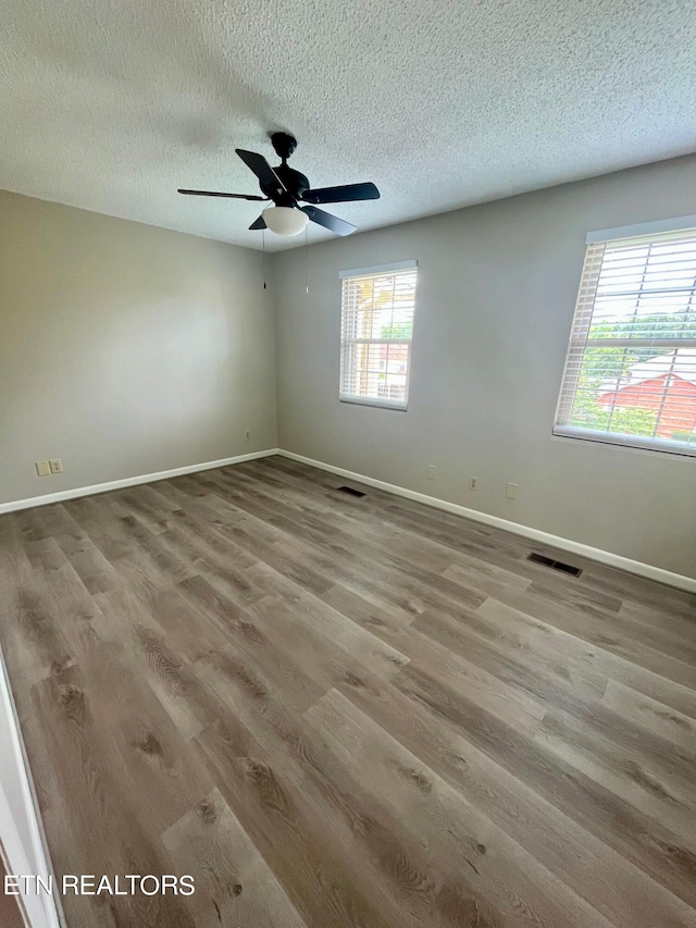 spare room with ceiling fan, hardwood / wood-style flooring, and a textured ceiling