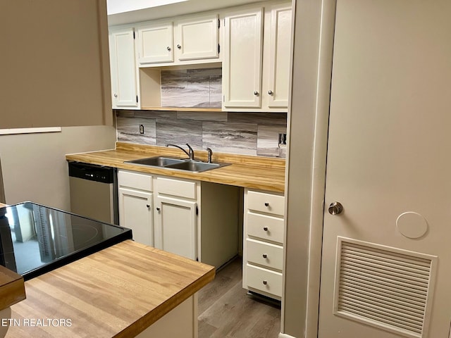 kitchen featuring stainless steel dishwasher, hardwood / wood-style floors, white cabinets, and sink