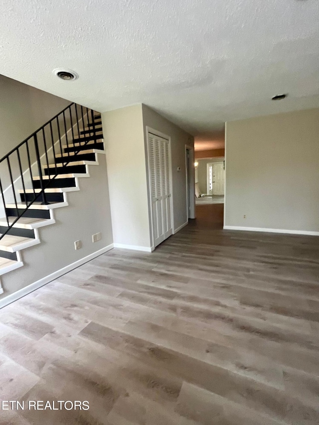 interior space featuring wood-type flooring and a textured ceiling