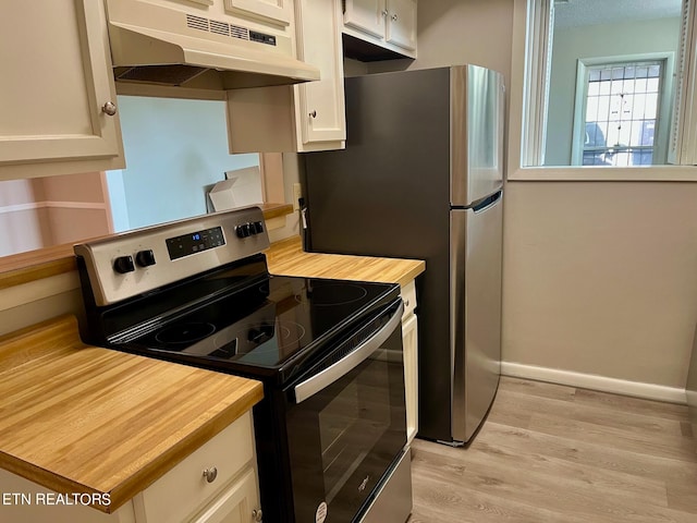 kitchen featuring appliances with stainless steel finishes, light hardwood / wood-style flooring, and white cabinetry