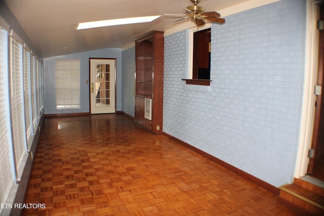 hallway with brick wall, baseboards, and lofted ceiling