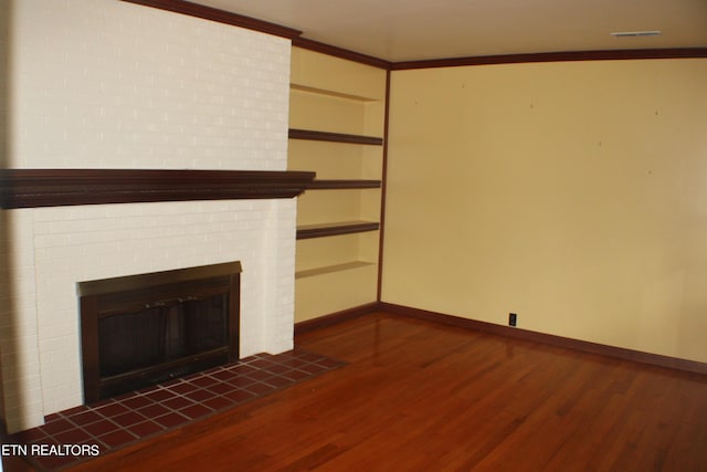 unfurnished living room with baseboards, crown molding, dark wood-type flooring, and a brick fireplace