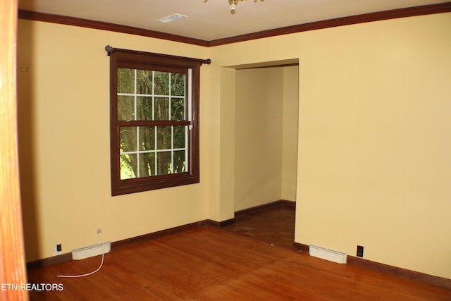 empty room with visible vents, crown molding, and dark wood-type flooring