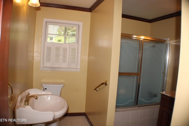 full bathroom featuring toilet, a sink, tile patterned flooring, baseboards, and ornamental molding