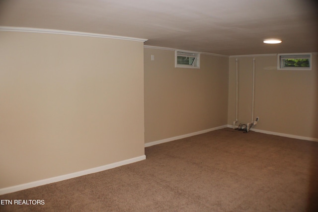 finished basement with baseboards, ornamental molding, and carpet