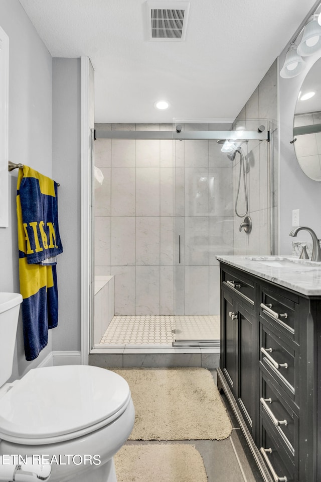 bathroom with walk in shower, vanity, and toilet