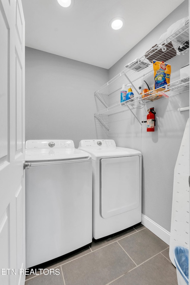 washroom featuring dark tile patterned floors and washer and clothes dryer