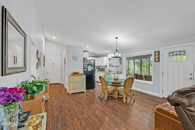 dining room featuring lofted ceiling, a chandelier, and dark hardwood / wood-style floors