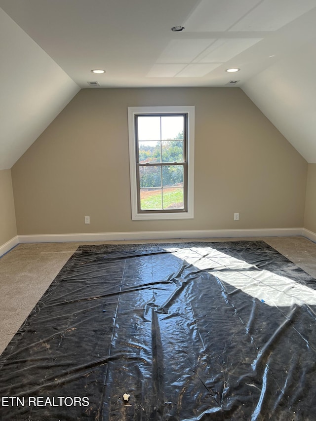 additional living space with carpet floors and vaulted ceiling