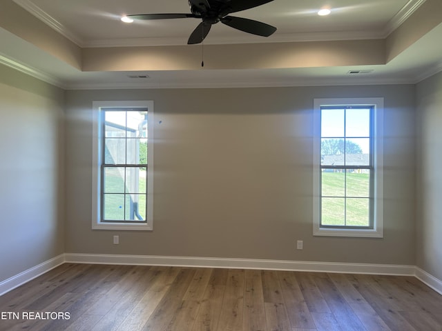 empty room with hardwood / wood-style flooring, plenty of natural light, and ornamental molding