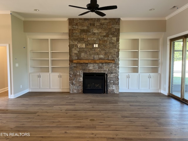 unfurnished living room with a stone fireplace, dark wood-type flooring, and ornamental molding