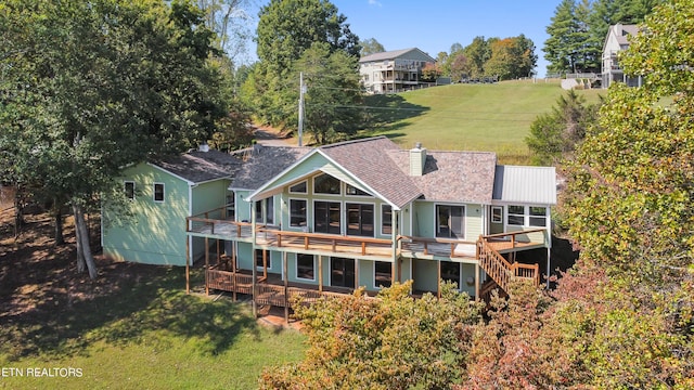 back of house featuring a lawn and a wooden deck