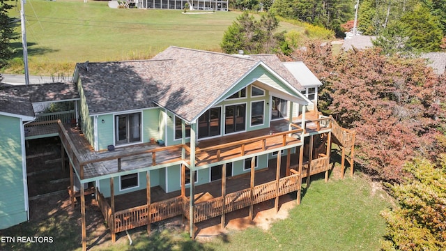 rear view of property featuring a yard and a wooden deck