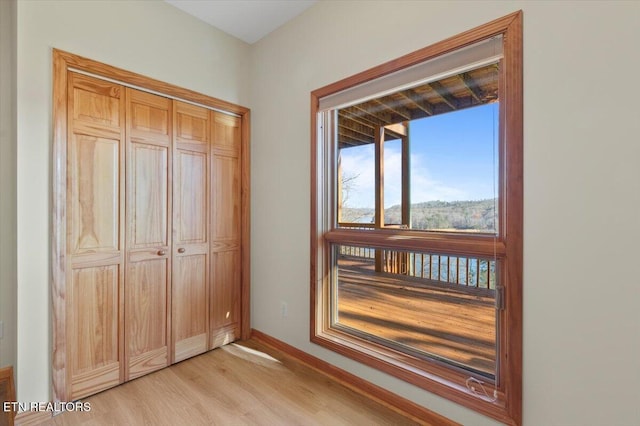 unfurnished bedroom with a closet and light hardwood / wood-style flooring