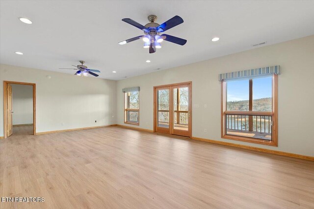 spare room with ceiling fan, a healthy amount of sunlight, and light hardwood / wood-style floors