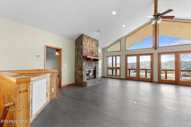 unfurnished living room featuring a fireplace, dark hardwood / wood-style flooring, high vaulted ceiling, and ceiling fan