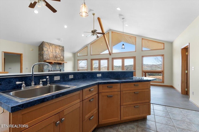 kitchen with black electric stovetop, vaulted ceiling, ceiling fan, sink, and a center island with sink