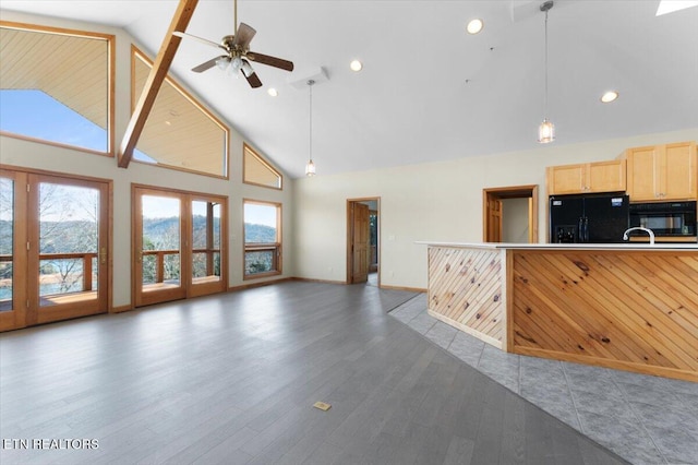 unfurnished living room with ceiling fan, dark hardwood / wood-style flooring, and high vaulted ceiling