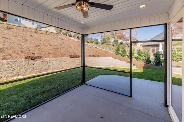 unfurnished sunroom featuring a ceiling fan