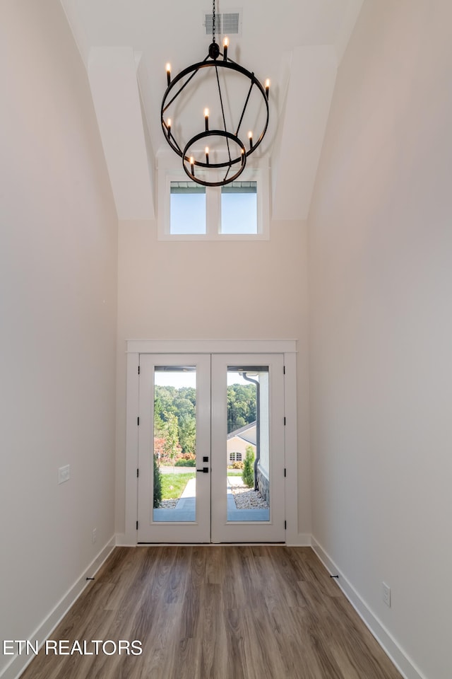 foyer with visible vents, baseboards, french doors, an inviting chandelier, and wood finished floors