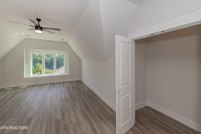 additional living space featuring lofted ceiling, wood finished floors, baseboards, and ceiling fan