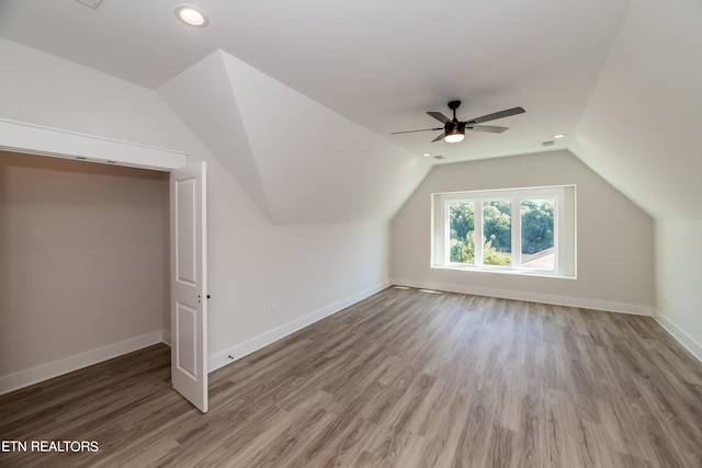 bonus room with baseboards, lofted ceiling, and wood finished floors