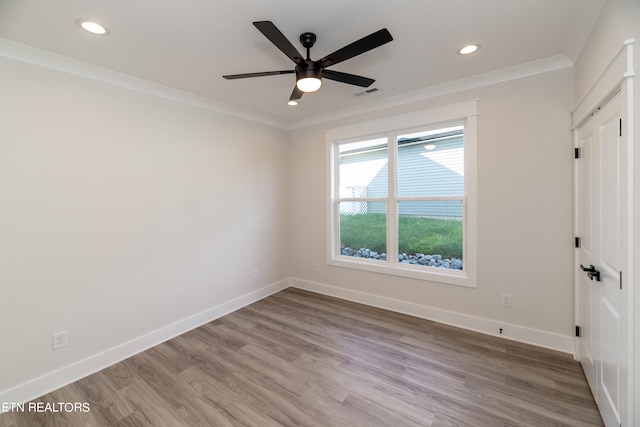 unfurnished room featuring visible vents, baseboards, wood finished floors, and crown molding