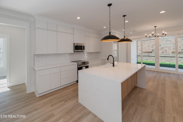 kitchen with modern cabinets, tasteful backsplash, appliances with stainless steel finishes, and a sink