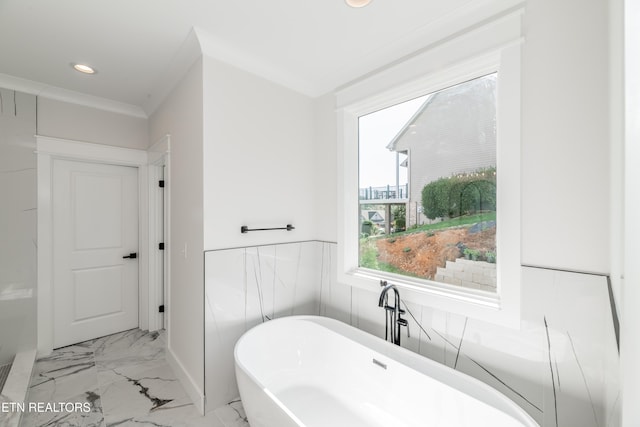 bathroom with recessed lighting, marble finish floor, crown molding, and a freestanding tub