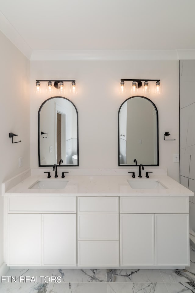 full bathroom with double vanity, ornamental molding, and a sink