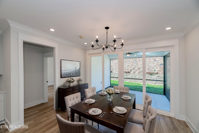 dining space featuring an inviting chandelier, baseboards, light wood finished floors, and ornamental molding