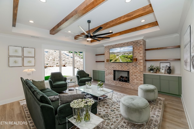 living area with baseboards, beam ceiling, a brick fireplace, and light wood-style flooring