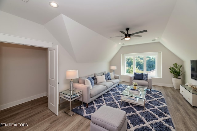 living room featuring lofted ceiling, recessed lighting, wood finished floors, and baseboards