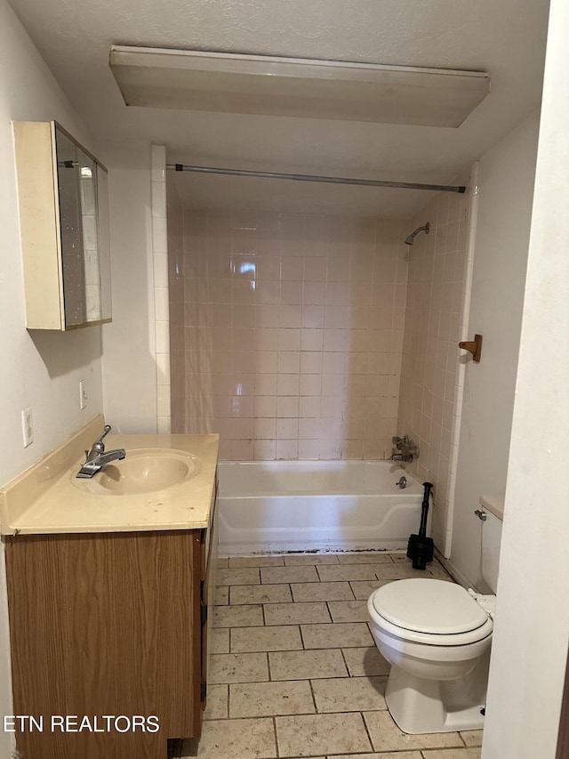 full bathroom with tiled shower / bath combo, vanity, and toilet