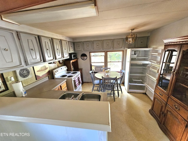 600 W 7th Ave, Lenoir City, TN 37771 - kitchen with decorative light fixtures, an inviting chandelier, stainless steel microwave, white electric range oven, and light floors